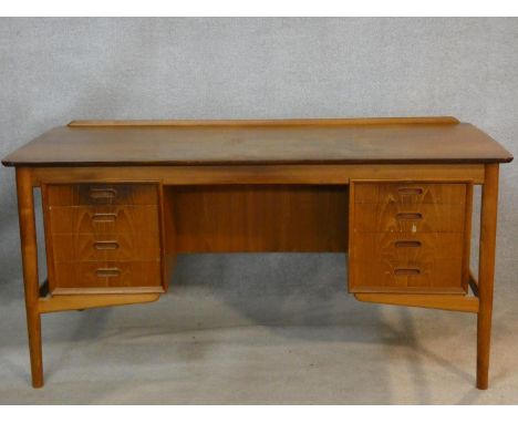 A 1960's vintage Danish teak desk fitted with two banks of drawers opposing open shelves and fitted cabinet. H.73 L.153 W.74c