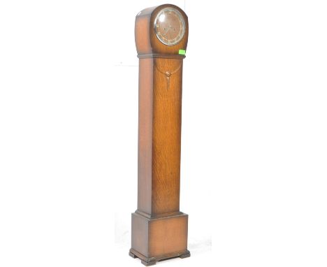 A 20th century circa 1930s Art Deco oak cased floor standing granddaughter clock. Raised on bracket feet, carved necklace des