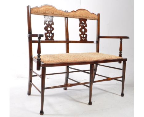 Edwardian mahogany two seater salon bench settee. Having a shaped arched, padded back rest, with flat elbow rest and matching