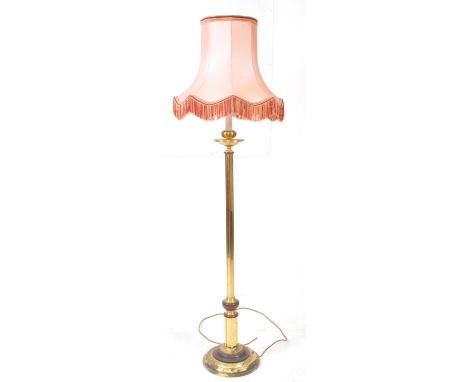 20th century brass standard floor lamp. Featuring a circular turned base and column shaped body with light fixture atop. Meas