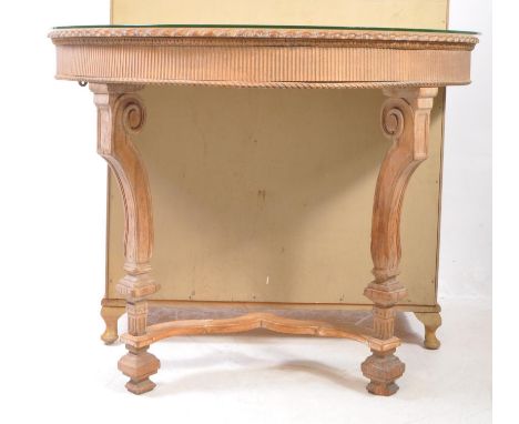 An early 20th century demi Lune hall / console table with glass top. Pie crust edge with reeded frieze, turned legs united by