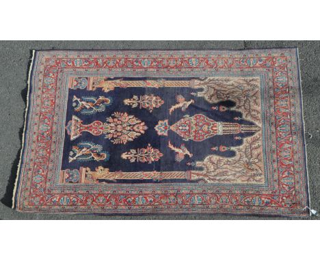 A 20th century Persian Ghom carpet rug. The rug having a sparsely populated deep blue central field, featuring decorative bir