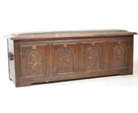 20th century Jacobean Revival bench coffer chest. Having a padded overstuffed top with stud work border, carved Knight's head