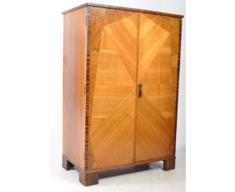 An early 20th century Art Deco walnut bachelors wardrobe / linen closet. The wardrobe raised on block feet, with two doors to