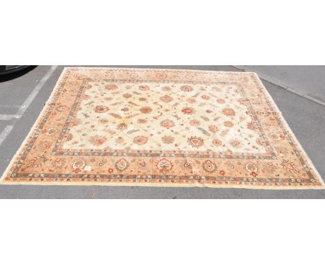 A large 20th century Persian style carpet floor rug. The rug having cream ground, with large central field populated with flo