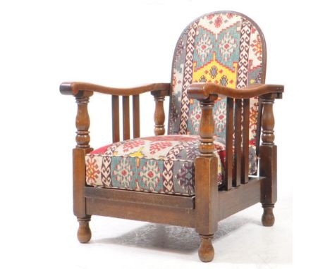 An early 20th century arts and crafts Morris style upholstered armchair. Features a oak curved back, scrolled armrests raised