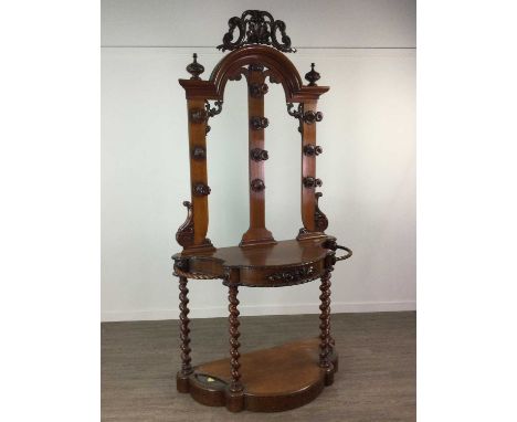 VICTORIAN OAK HALL STAND,with carved shell and scroll surmount and twin finials above domed superstructure, with ten foliate 