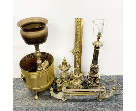 A brass fireplace set together with a table lamp and other items.
