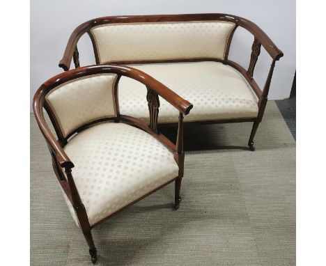 An early 20thC carved mahogany and upholstered settee on castors with matching tub chair, settee 120 x 60 x 76cm.