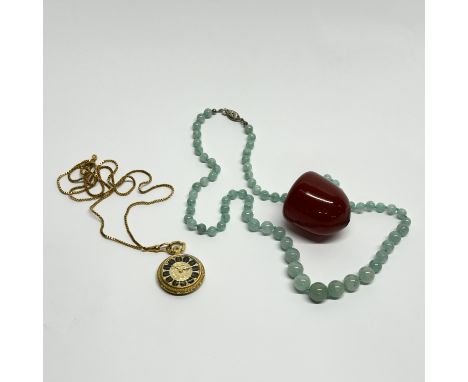 A graduated serpentine necklace with a large amber bead and a gold plated pendant watch and chain.