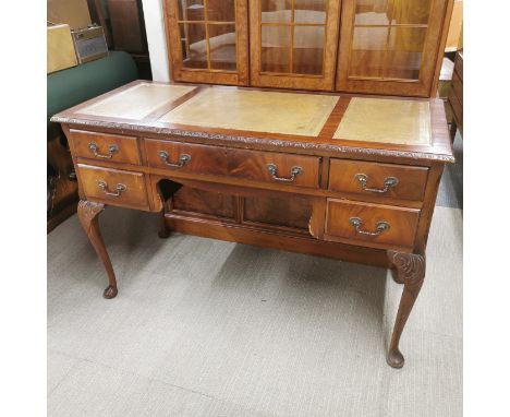 An early 20thC leather topped five drawer carved mahogany writing desk, 121 x 55 x 78cm.