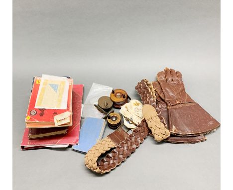 A box of mixed items including vintage leather gloves, fishing reels and cigarette silks.