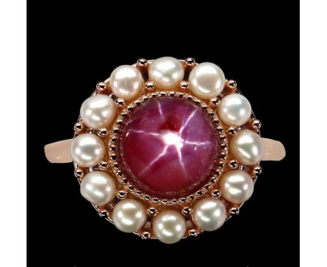 A rose gold on 925 silver ring set with cabochon cut ruby surrounded by pearls, ring size O.