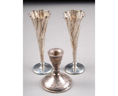A pair of planished silver trumpet vases with loaded bases and a sterling silver candlestick (filled) 