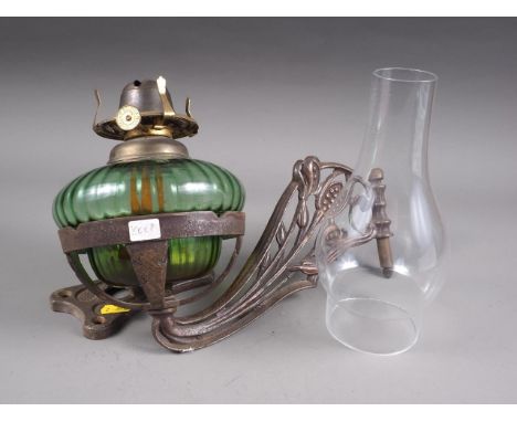 An early 20th century oil lamp with green glass reservoir and cast iron bracket and chimneyCondition:No visible issues to the