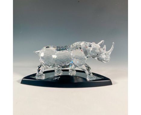 A clear crystal figure that intricately captures the strength and majesty of a rhinoceros standing proudly. Includes a dark b