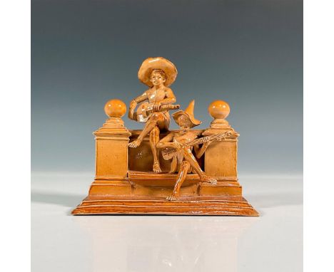 Stoneware salt glazed figure of the Merry Musicians series. Modeled as two boys playing instruments seated on a bench flanked