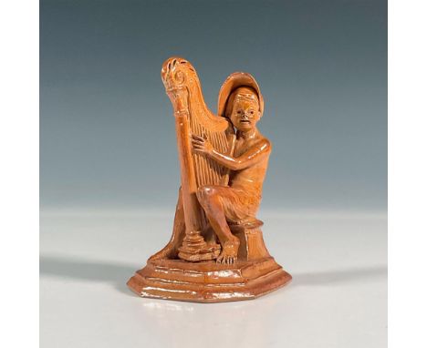 Stoneware salt glazed figure of Merry Musicians series. Features a boy seated on a chair playing the harp. Incised George Tin
