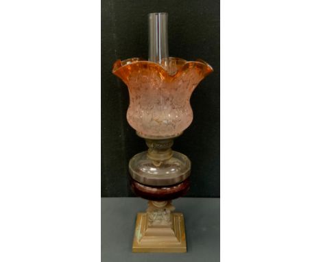 A Victorian cranberry glass oil lamp, bronzer coloured base stepped foot, Corinthian capital, clear glass reservoir, multi to