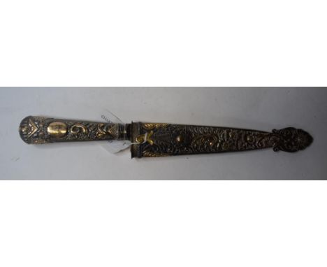 A South American dagger, with a silver coloured metal handle and scabbard with yellow coloured metal decoration, the blade st