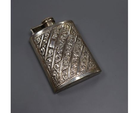 An embossed white metal hip flask inscribed 'sterling silver', 11.6cm.