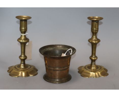 An 18th century bronze mortar and a pair of 18th century brass candlesticks