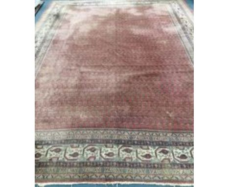 A Ferraghan carpet with multiple lines of guls on a wine ground 330 x 420cm