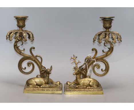 A pair of bronze candlesticks modelled as recumbent deer (lacking glass lustres) height 28cm