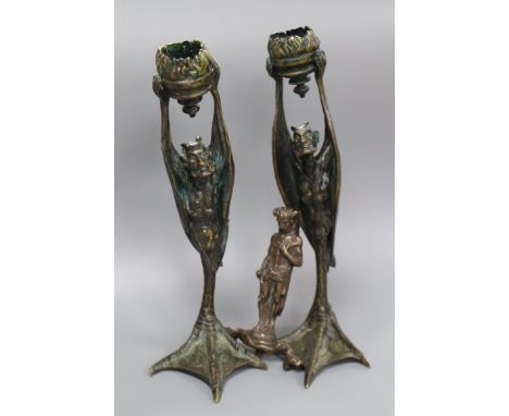 A pair of cast bronze candlesticks and another similar figure