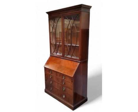 A Victorian mahogany and satinwood inlaid secretaire bookcase, the oversailing dental cornice above two fretwork panelled gla