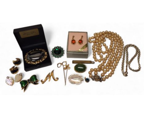 A 9ct gold 'M' stick pin, 1.1g; another gold plated spectacles stick pin; a gold plated mounted oval jadeite cabochon; a Sphi