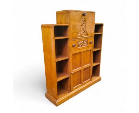 An Art Deco golden oak student's bureau, the fall front carved with Celtic design revealing pigeon holes above one drawer to 