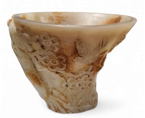 A Chinese 'white jade' libation cup, with prunus and birds, 10cm high