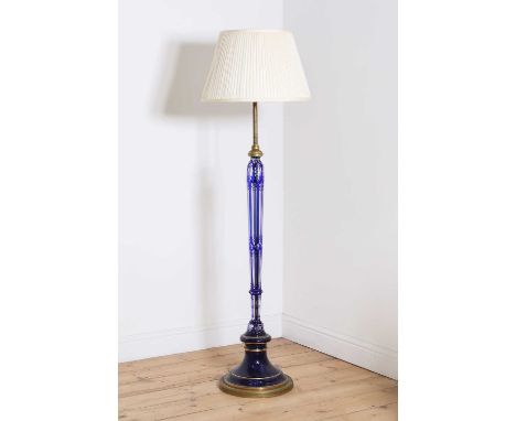 An overlaid glass and brass standard lamp,20th century, with blue overlay and panelled decoration on a turned brass and ename