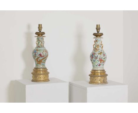 A pair of Chinese porcelain vase lamps,mid-19th century, each baluster-shaped vase with gilt 'mythical beast' handles and fur