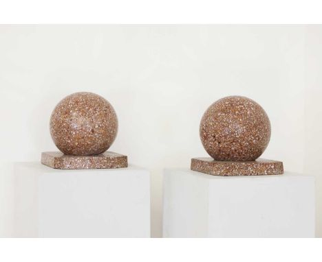 A pair of polished terrazzo orbs,each on an original, canted square stand, c.1930,26cm high (2)The orbs with general surface 
