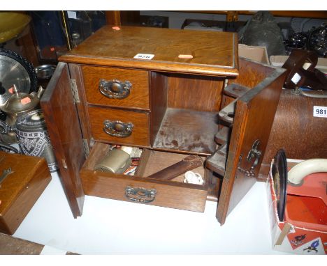 AN EDWARDIAN OAK SMOKERS COMPENDIUM, with pipes, cigarette roller etc (key)