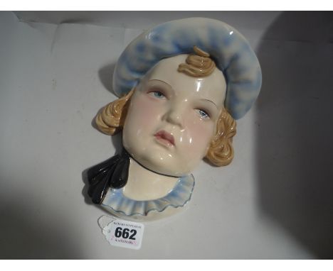 A GOLDSCHEIDER POTTERY WALL MASK, model No.7409, modelled as a head of a girl wearing a bonnet, impressed and stamped Made in