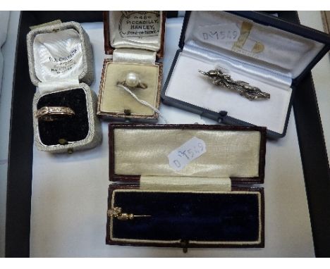 FOUR ITEMS OF JEWELLERY, to include two rings, a diamond stick pin and a floral brooch, all within fitted boxes