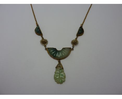 A JADE NECKLACE, designed as three fans with a pear shape dropper to the filigree flower spacers