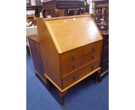 A LIGHT OAK WRITING BUREAU, with three long drawers