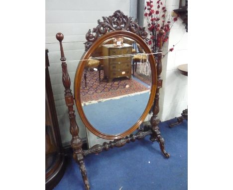 A VICTORIAN MAHOGANY FIRESCREEN/MIRROR, with heavily carved frame (s.d.)
