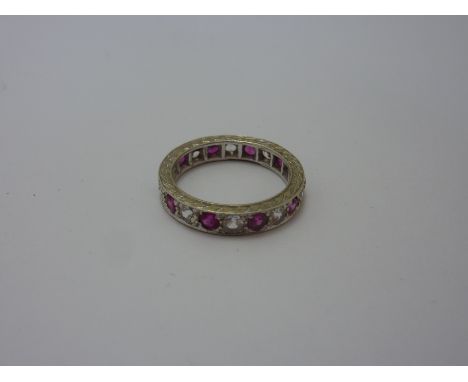 AN EARLY 20TH CENTURY RING, designed as ruby coloured paste and claer paste stones to engraved sides, stamped 375, ring size 