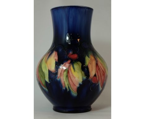 Moorcroft vase decorated in the Leaf & Berry design, height 23cm  (slight glaze fault to base edge and two small chips to top