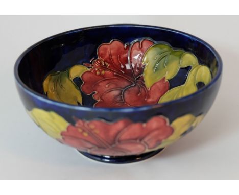 Moorcroft footed bowl decorated in the hibiscus design on blue ground, diameter 16cm