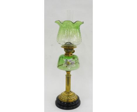 A VICTORIAN BRASS REEDED COLUMNAR OIL LAMP, THE SHADED GREEN GLASS FOUNT ENAMELLED WITH A LILY, BRASS BURNER, ON BLACK GLAZED