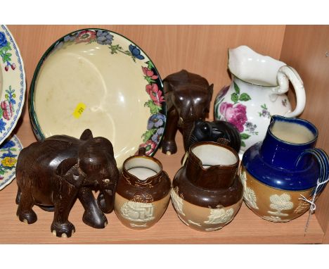 A SMALL GROUP OF ROYAL DOULTON AND THREE CARVED ELEPHANTS, to include three stoneware tavern and hunting scene jugs, of vario