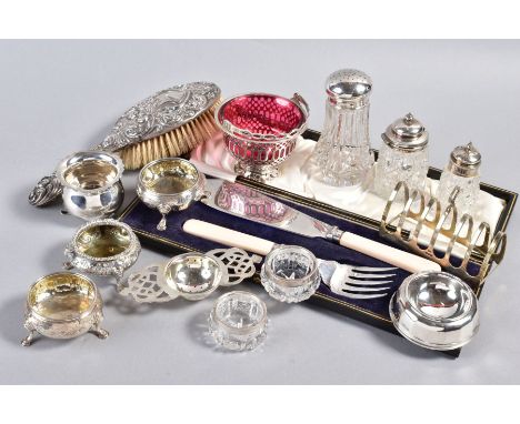 A SELECTION OF MAINLY SILVERWARE, to include a toast rack, an embossed hairbrush, a bon bon dish with pink glass liner, condi
