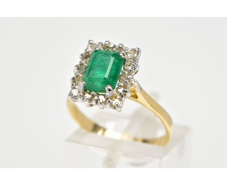 AN EMERALD AND DIAMOND RING, designed with a central rectangular cut emerald and a single cut diamond surround, to the tapere