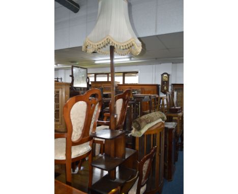 AN EARLY TO MID 20TH CENTURY OAK STANDARD LAMP on a base with an assortment of open shelves, height minus light fitting 149cm